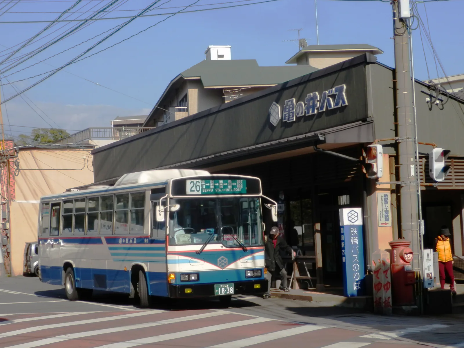 掛著龜之井巴士招牌的鐵輪候車處前,停著一輛26號路線巴士