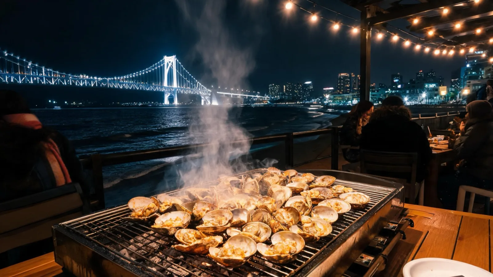 A table with Gwangalli grilled clams and the night sea view