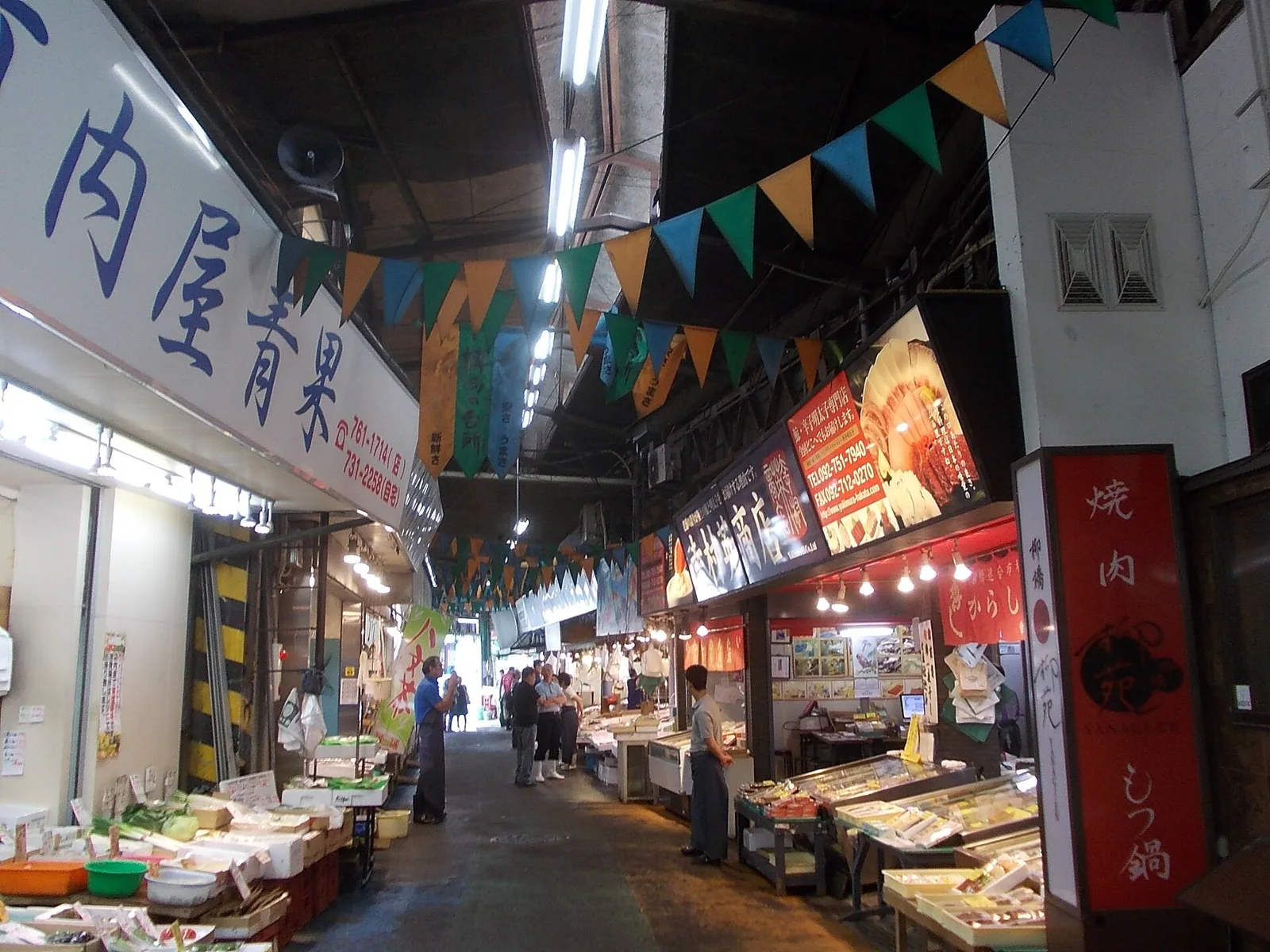 The narrow aisle of Yanagibashi Rengo Market, with bunting under the roof and shops on both sides