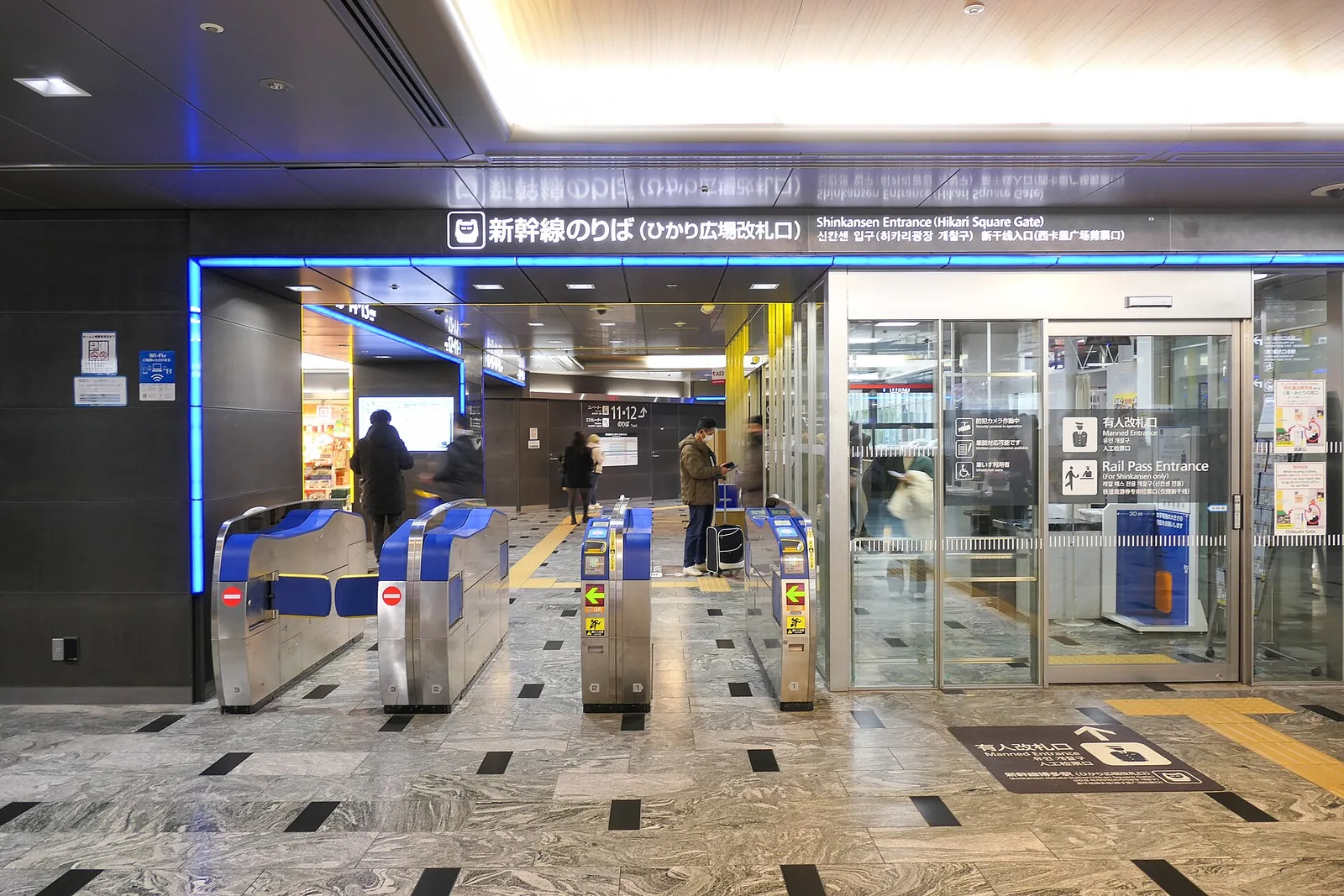 The Shinkansen Hikari Plaza ticket gate at Hakata Station, with blue-lit signs above the gates