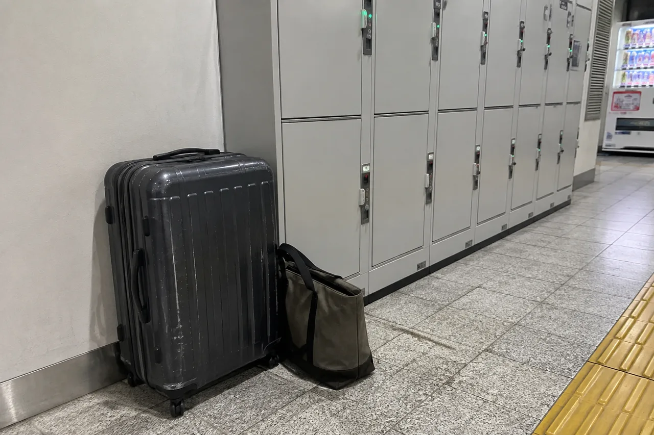 A suitcase and tote beside metal coin lockers