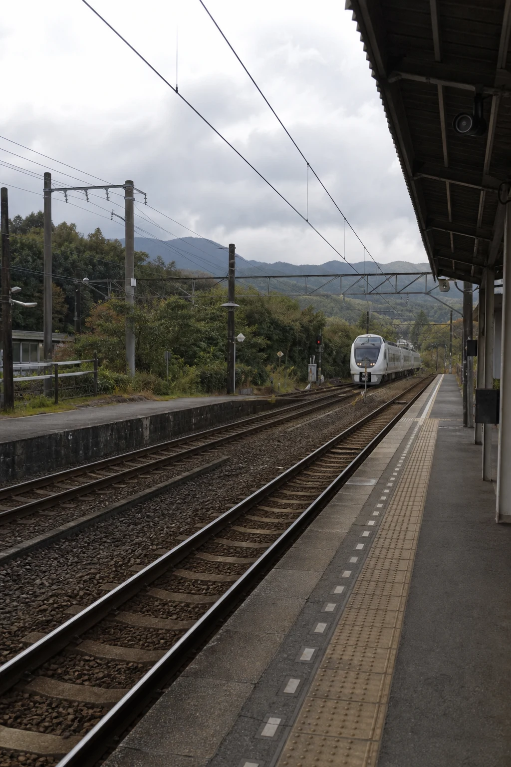 Rail platform with a train in the distance
