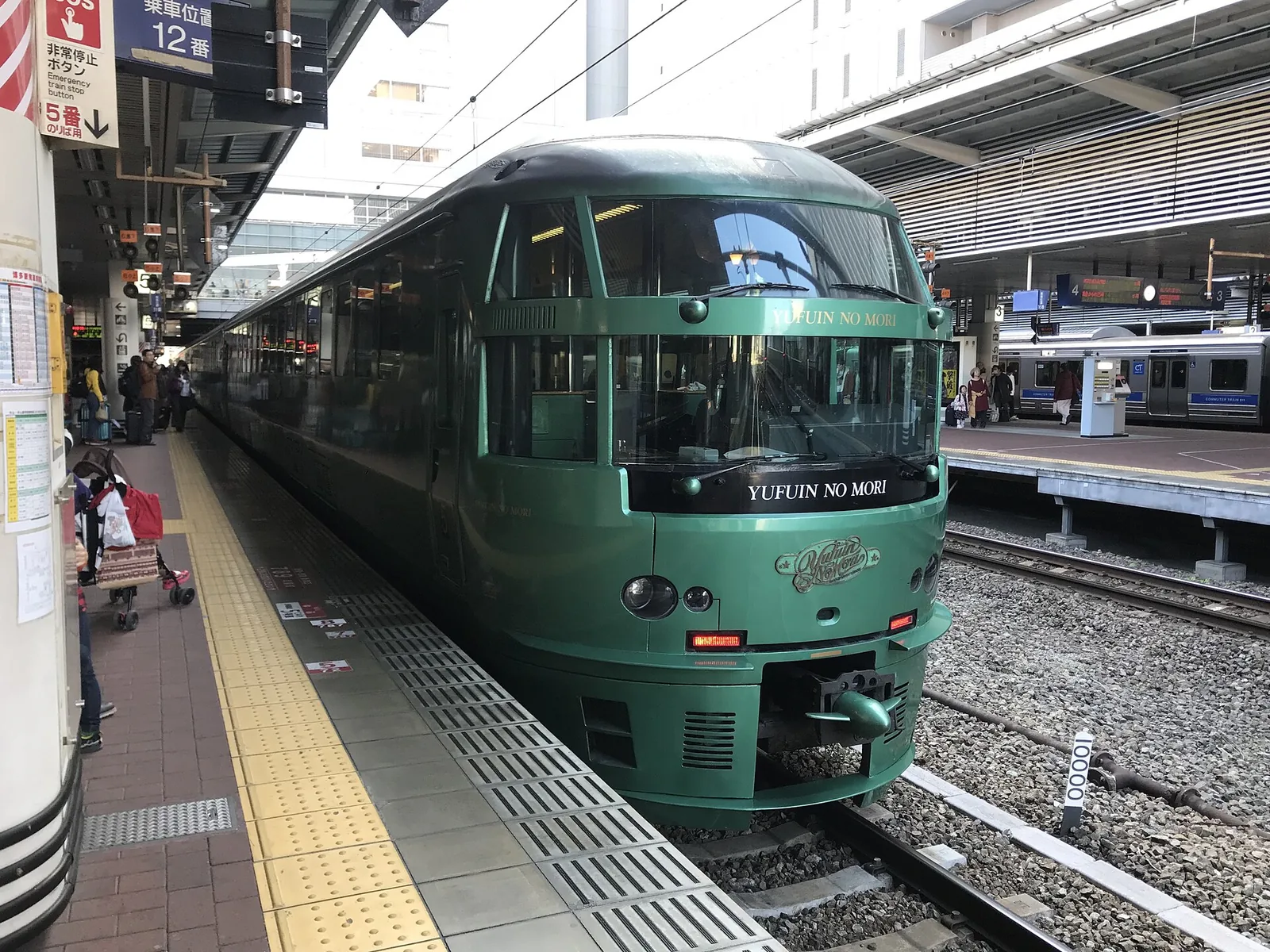 停靠在博多車站月台旁的綠色「由布院之森」列車，車頭呈圓弧造型