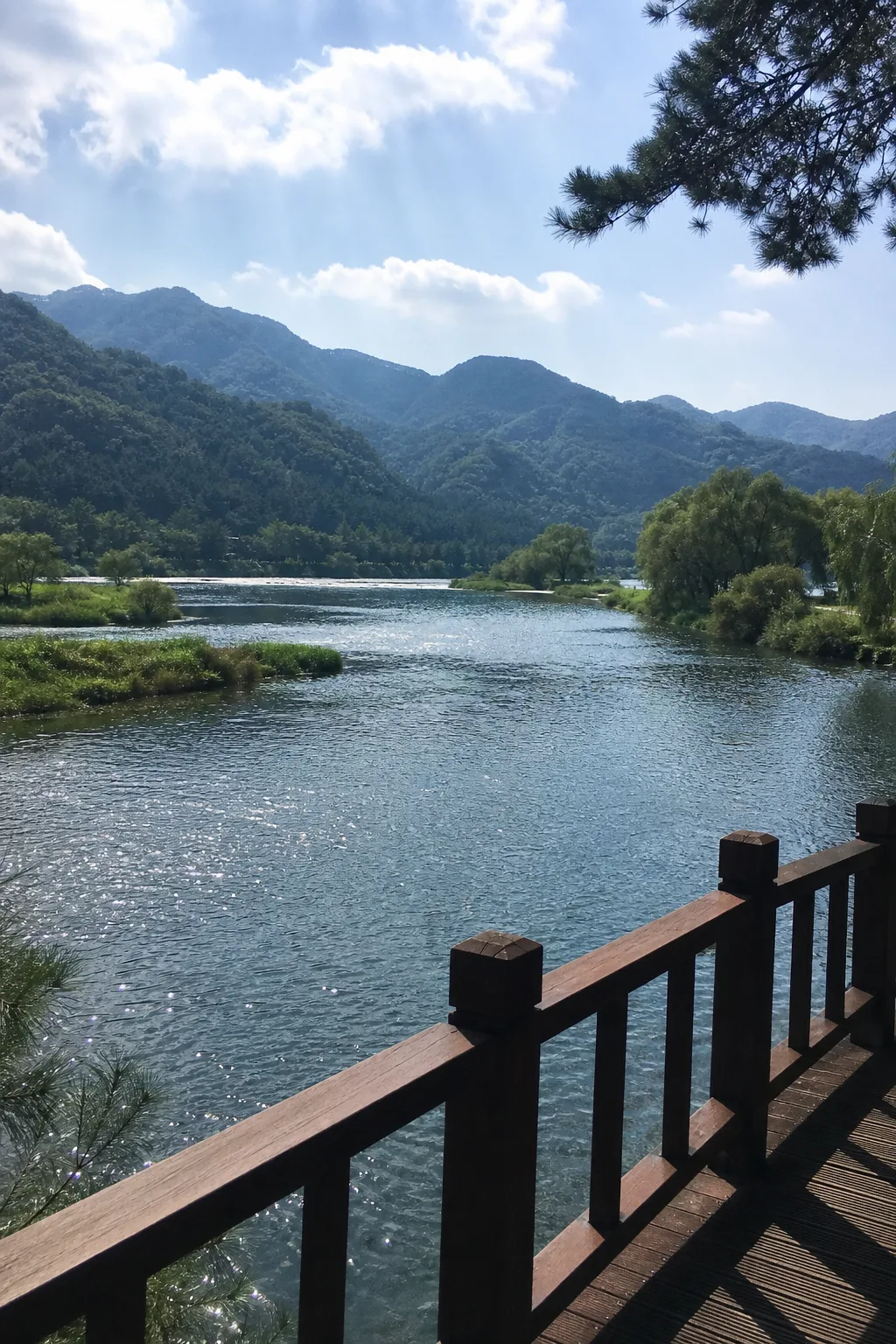 A river overlooked by a wooded mountain ridge