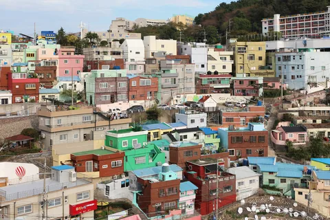 Colorful houses stacked up a hillside in Gamcheon Culture Village, Busan, with stairs and rooftops in between