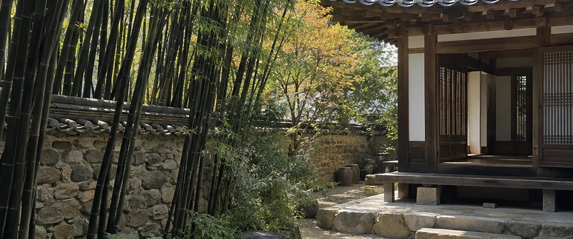 A grove of black bamboo beside a tiled-roof hanok and a gravel courtyard.