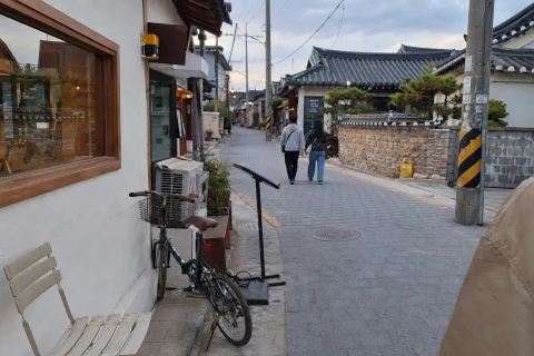 A lived-in tiled-roof café street at the start of a central Gyeongju walk, shown as an AI-generated reference image