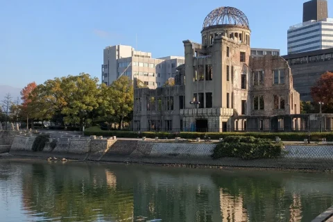 The Atomic Bomb Dome seen across the calm river in morning light