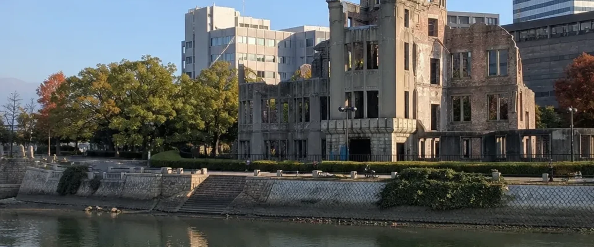 The Atomic Bomb Dome seen across the calm river in morning light