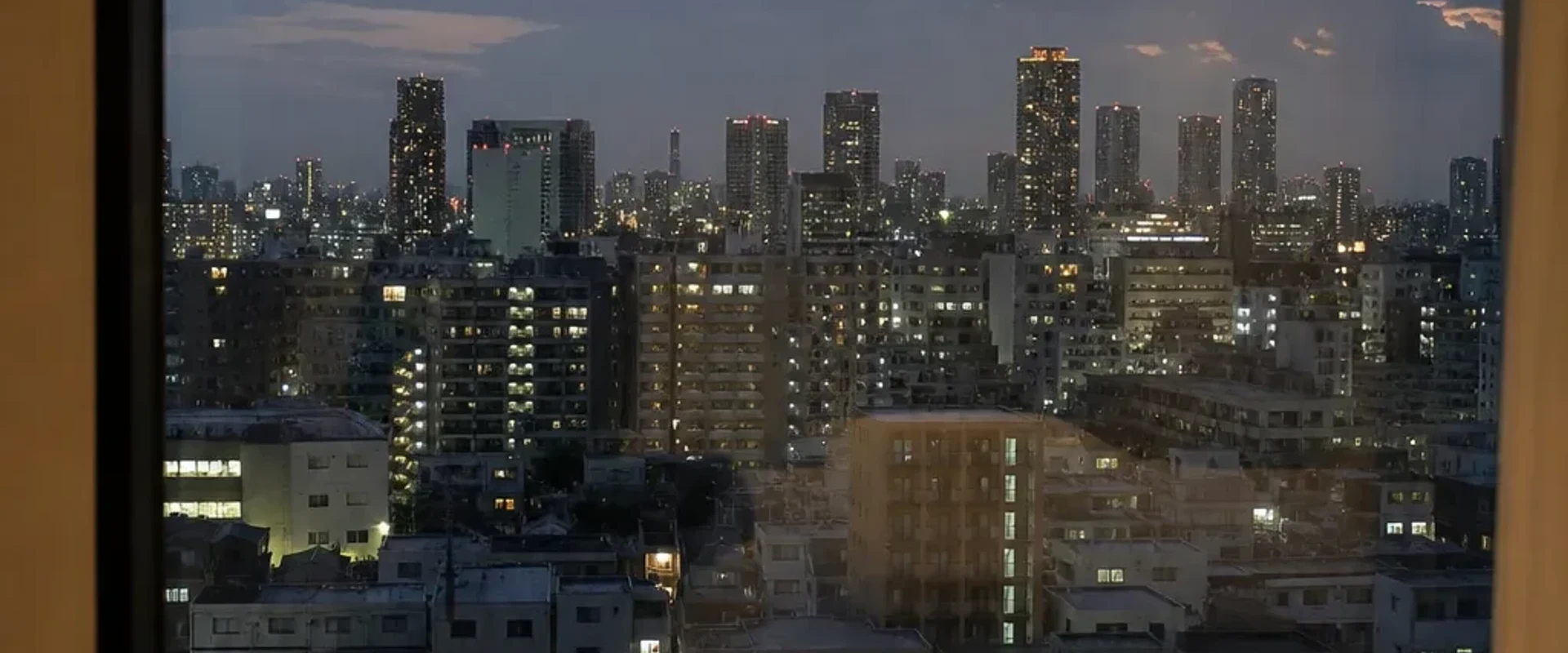 Tokyo skyline at dusk seen through a hotel window