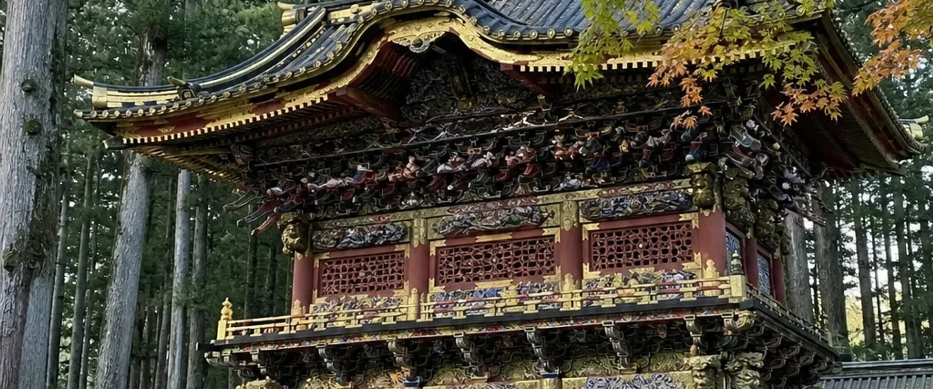 Nikko Toshogu shrine gate with dense carvings among cedars
