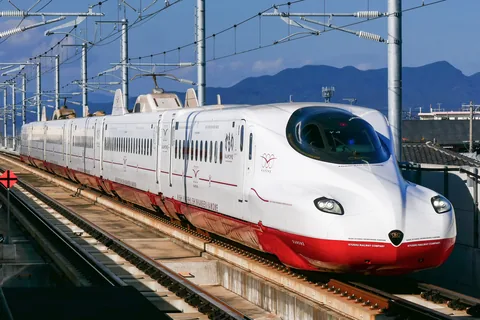A red and white Kamome shinkansen on the Nishi Kyushu Shinkansen line, with mountains behind