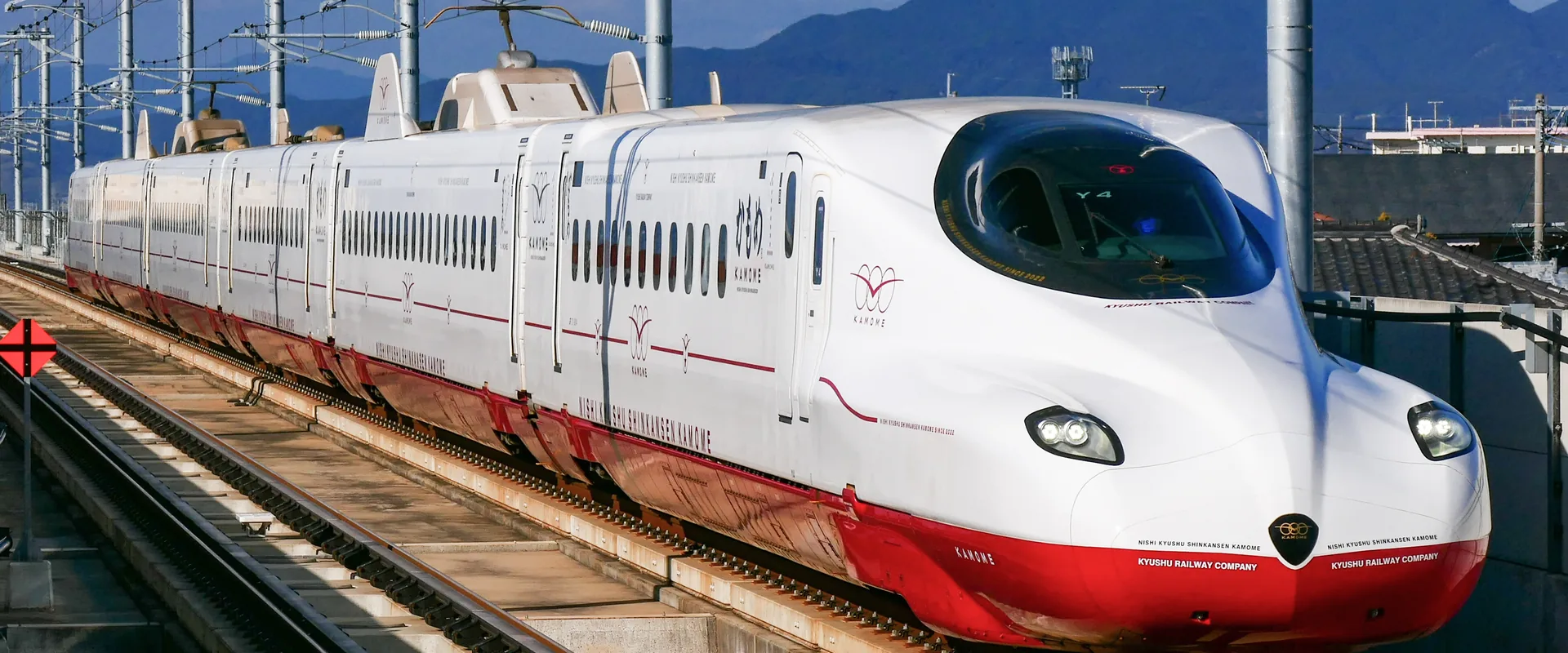 A red and white Kamome shinkansen on the Nishi Kyushu Shinkansen line, with mountains behind