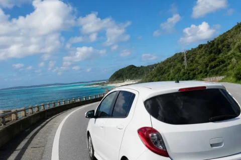 A rental car driving along Okinawa's coastal road