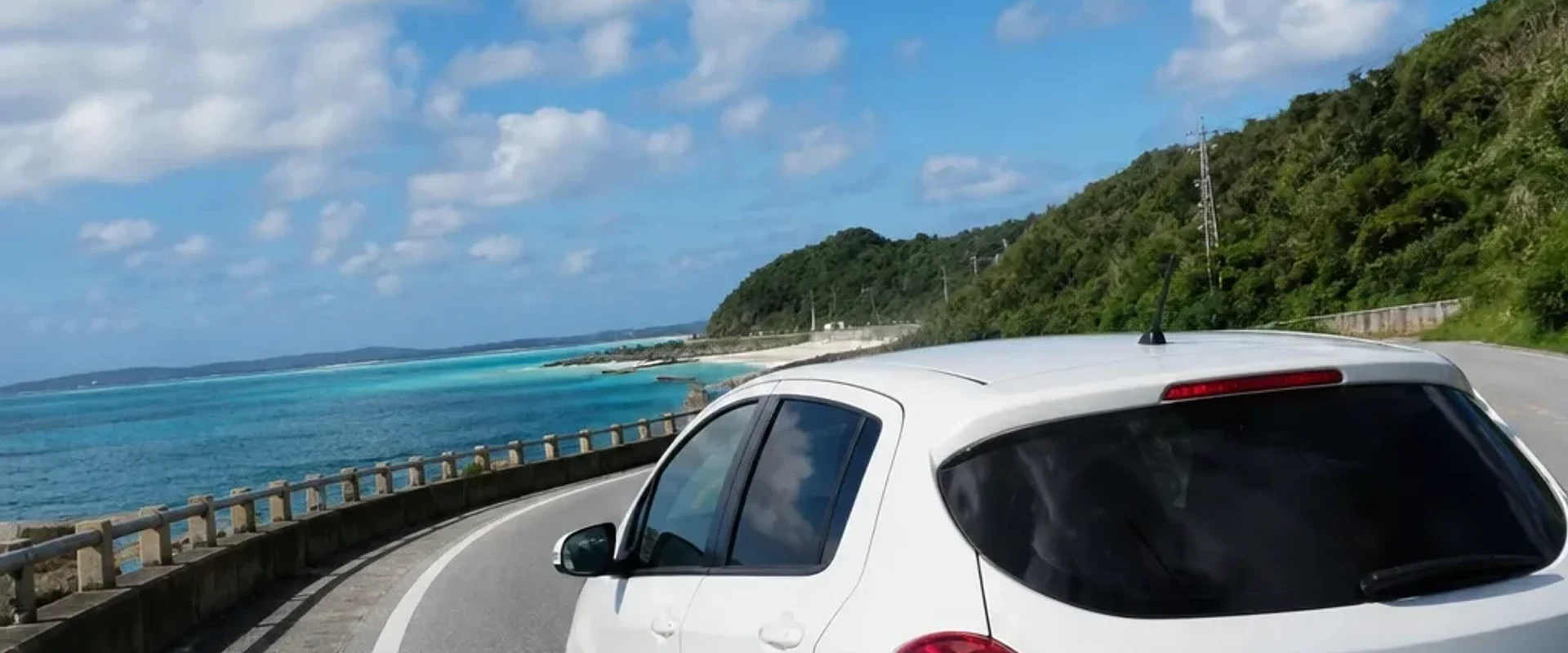 沿著沖繩海岸公路行駛的白色租車