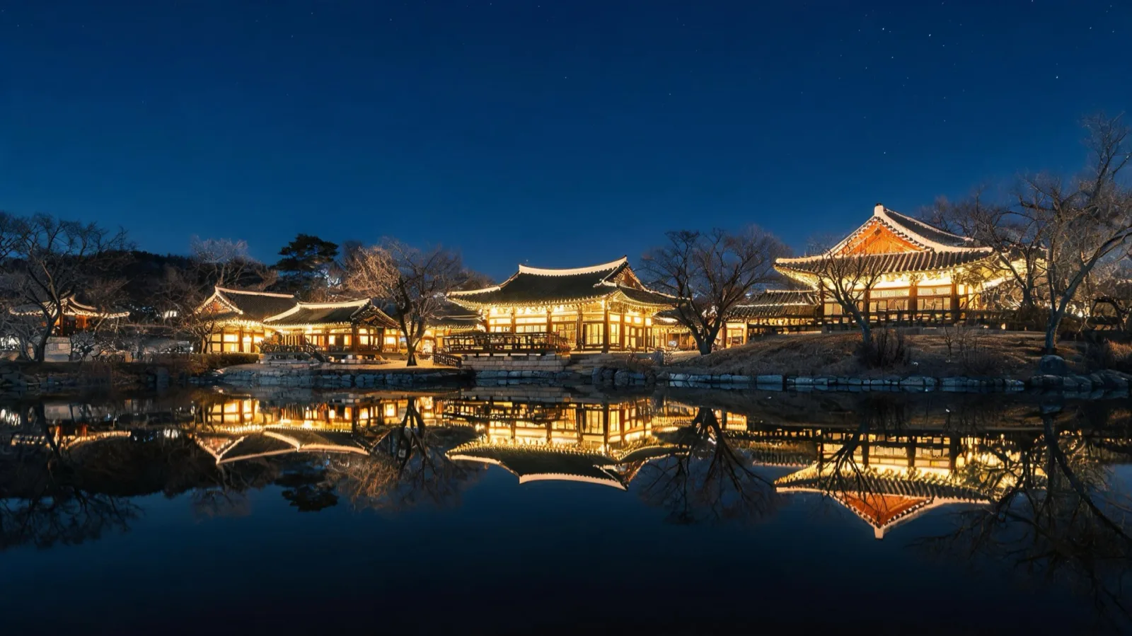 Illuminated traditional pavilions reflected in water