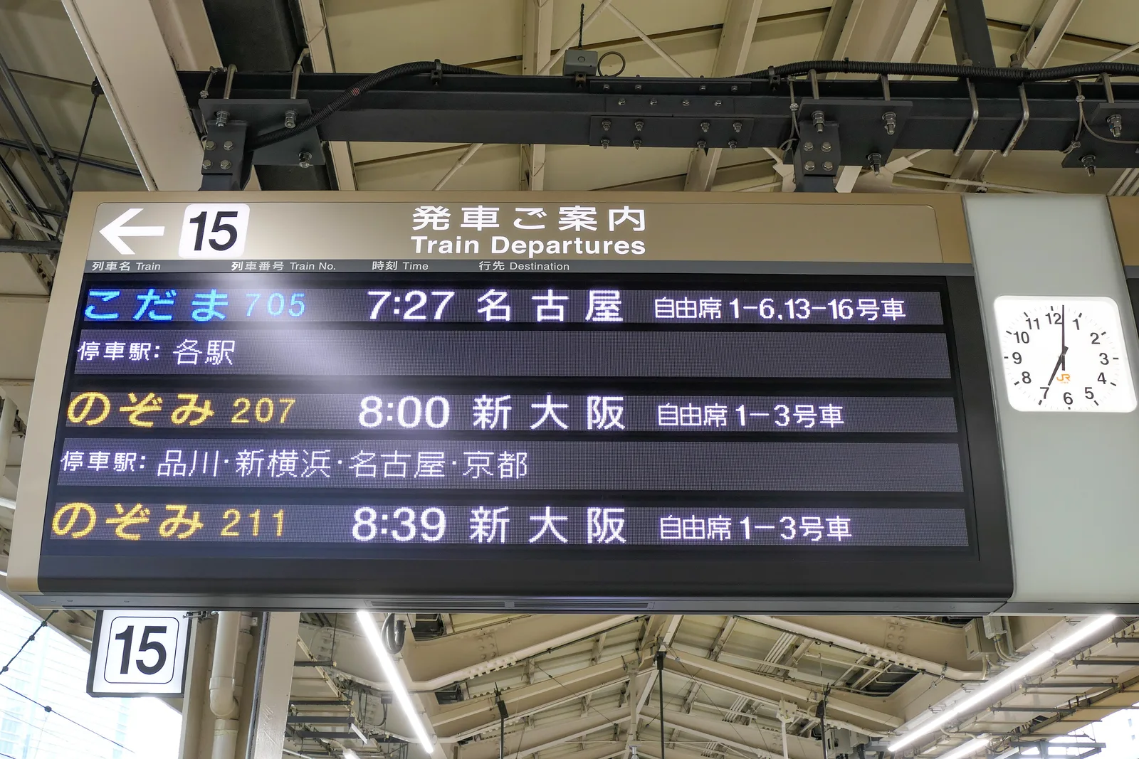 Departure board on a Tokaido Shinkansen platform at Tokyo Station listing one Kodama and two Nozomi trains