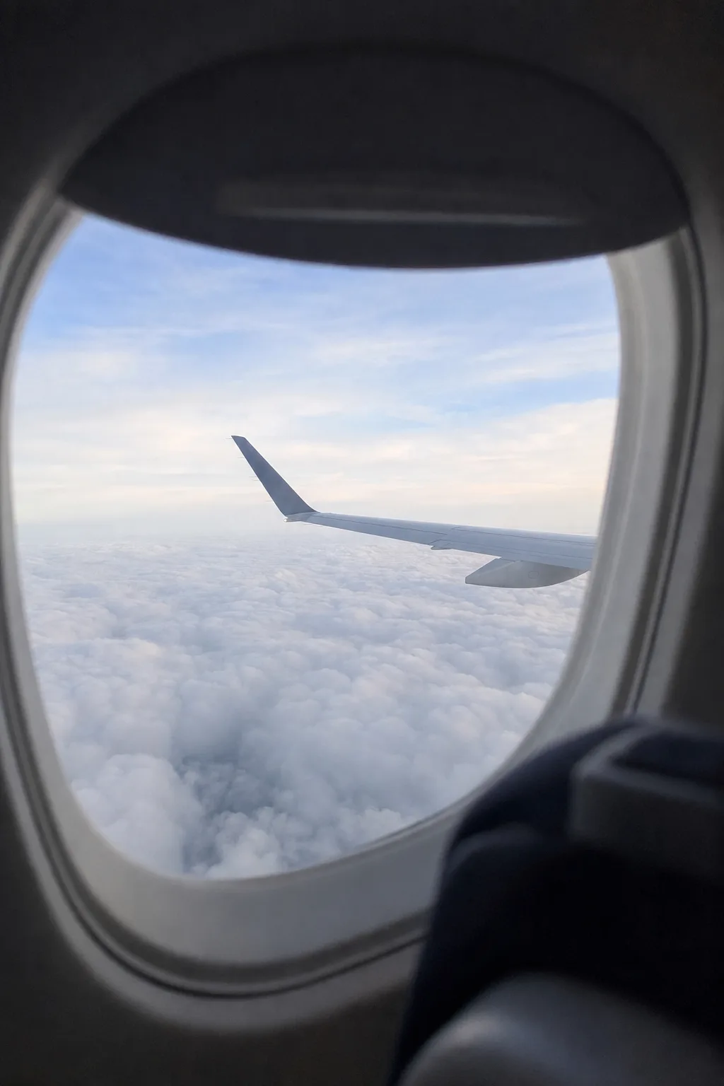 Airplane wing over clouds