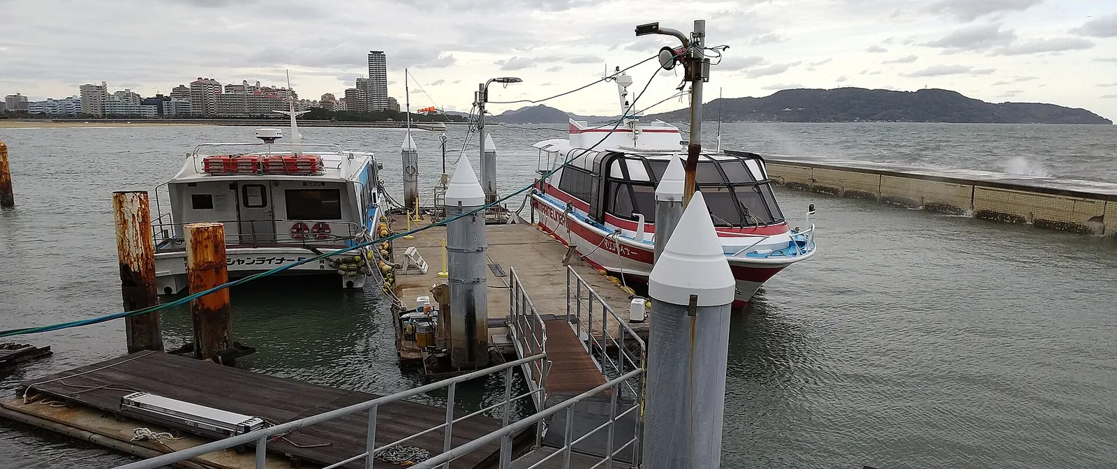 Two small Uminaka Line fast boats moored side by side at the Marizon pier in Momochi