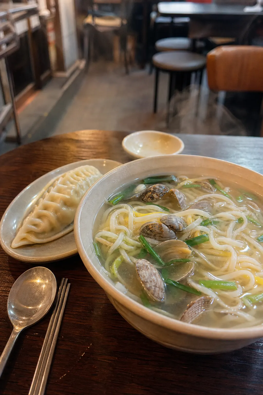 A bowl of kalguksu and mandu atmosphere