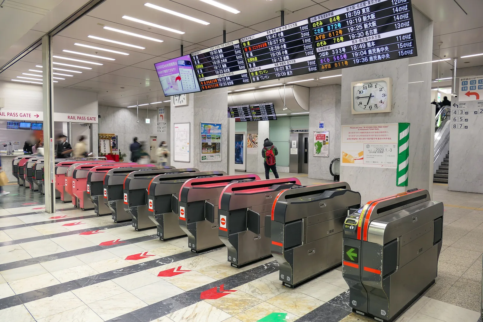 Central ticket gate of JR Hakata Station with a separate rail pass gate on the left and departure boards above
