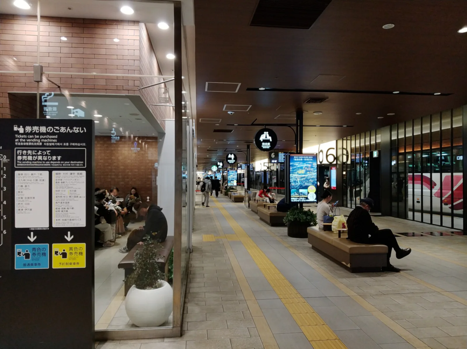Boarding area of the Nishitetsu Tenjin Expressway Bus Terminal with seating and departure signs