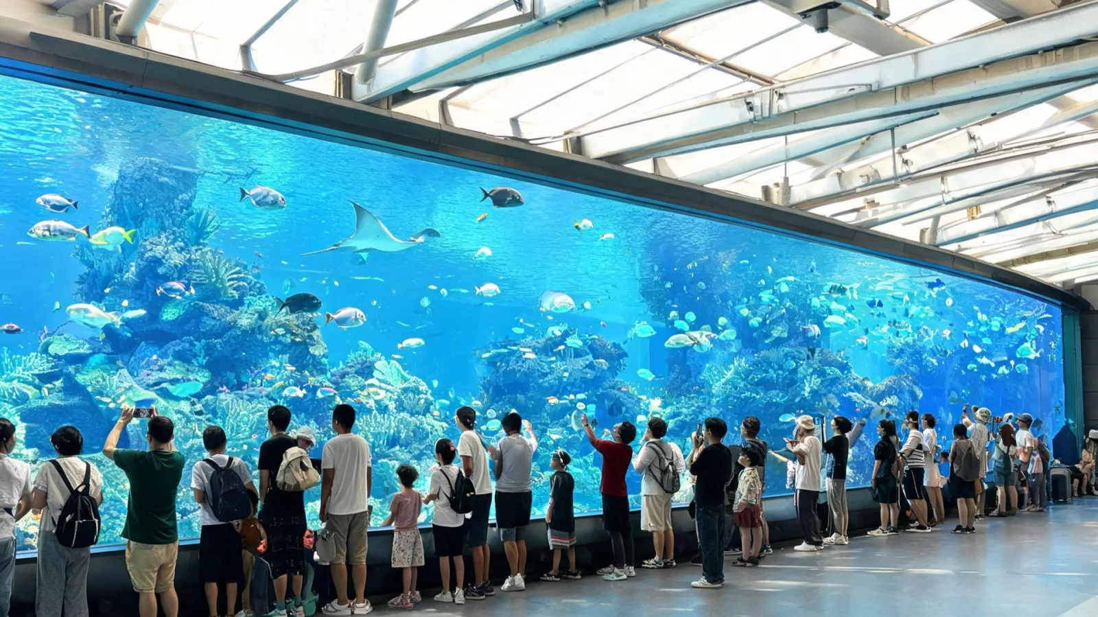 Visitors looking at the large tank at Churaumi Aquarium