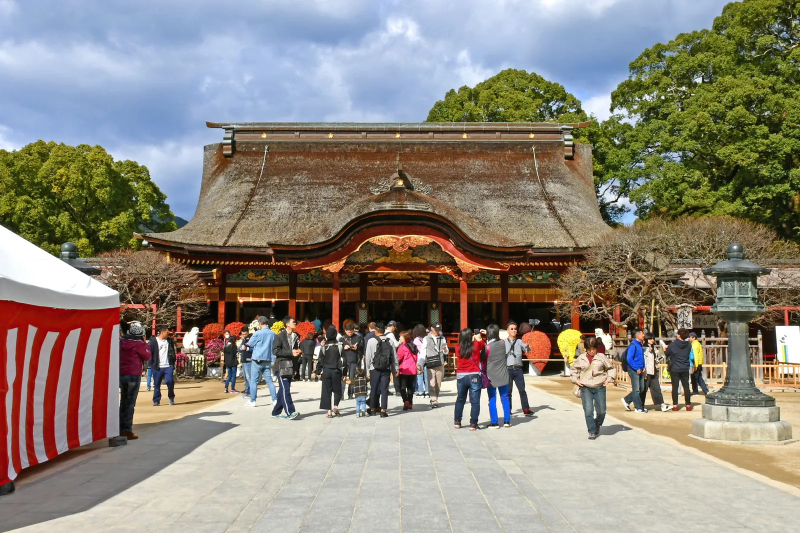 The heavy-roofed main hall of Dazaifu Tenmangu, with visitors gathered in the stone courtyard in front